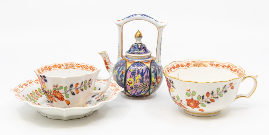 A decorative Meissen cup and saucer, along with another cup in the 19th Century style, along with