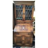 A Jacobean style 'Old Mill oak bureau bookcase with leaded glass, together with oak corner