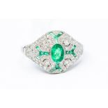 An emerald and diamond platinum boule cluster ring, comprising an oval emerald set to the centre,