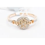 A diamond 10ct rose gold cluster ring, comprising a central dome set to the centre with a cluster of
