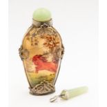 A Chinese scent bottle, jade lid and white metal applied decoration with a jade pendant, with