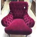 A large red velvet late Victorian armchair on casters with broken arm, needs attention