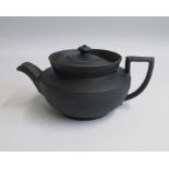 A Wedgwood Black Basalt Teapot and Cover, Engine turned with a turreted collar. Glazed inside