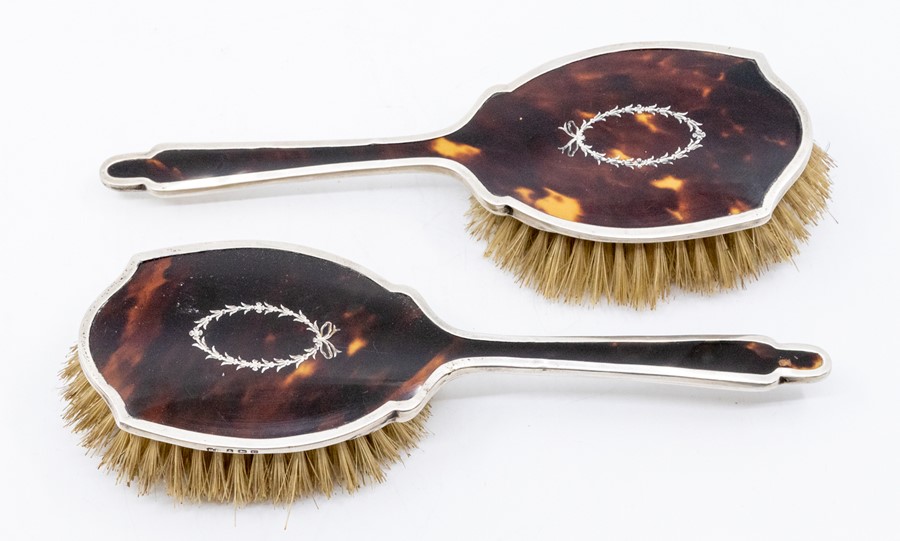 A pair of Edwardian silver mounted inlaid tortoiseshell dressing table brushes, the silver by Robert
