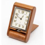 A Jaeger-LeCoultre leather-cased travel alarm clock, with eight day movement in tan folding case,