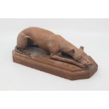 A 19th Century terracotta figure of a whippet or lurcher, modelled recumbent with its head resting