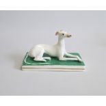 A Staffordshire Porcelain Greyhound/Whippet, laying on a green rectangular base. Circa 1840-50 Size: