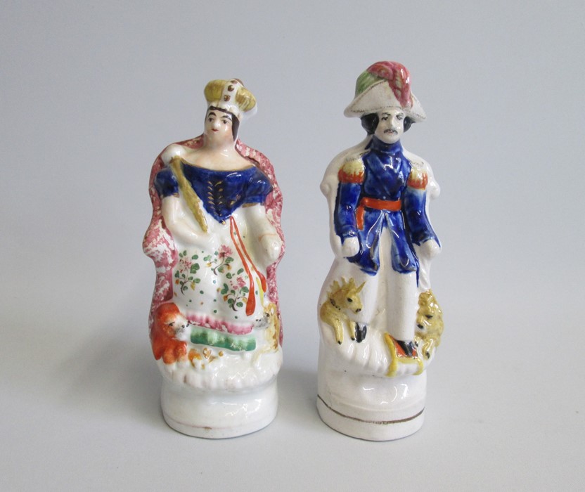 A pair of Staffordshire seated figures of Queen Victoria and Prince Albert.  Each with a lion and