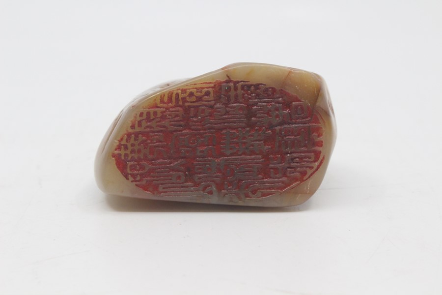 A Chinese pale green and russet jade seal, 20th Century, carved as a recumbent lion dog atop a rock, - Image 3 of 3