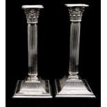 A pair of Edwardian silver Corinthian column candle sticks, of typical form on fluted and beaded