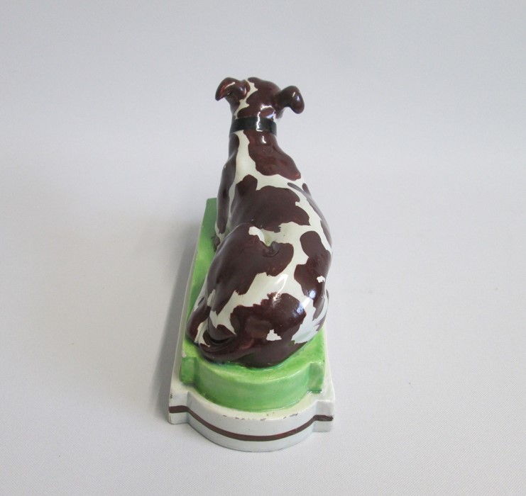 A Staffordshire model of a recumbent Greyhound/Whippet painted with brown markings, laying on a - Image 5 of 6