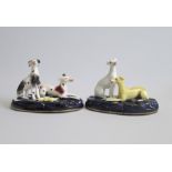 A Pair of Staffordshire Greyhound/Whippet groups, one with a hare, Seated on cobalt blue bases.