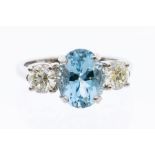 A aquamarine and diamond three stone platinum ring, the oval aquamarine weighing approx. 2.