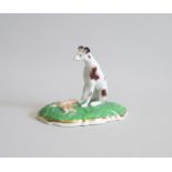 A Staffordshire Model of Hound and a Hare on a green cushion base. Date: 1840-50 Size: 9cm diameter,