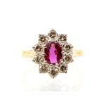 A ruby and diamond 18ct gold cluster ring, the oval ruby claw set to the centre weighing approx. 0.