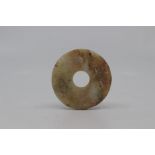 A Chinese pale green and russet jade disk, Bi, probably Qing Dynasty, the surface on both sides