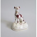 A Staffordshire Model of a seated Hound painted with Brown markings Date: circa 1850-60 Size: 7cm