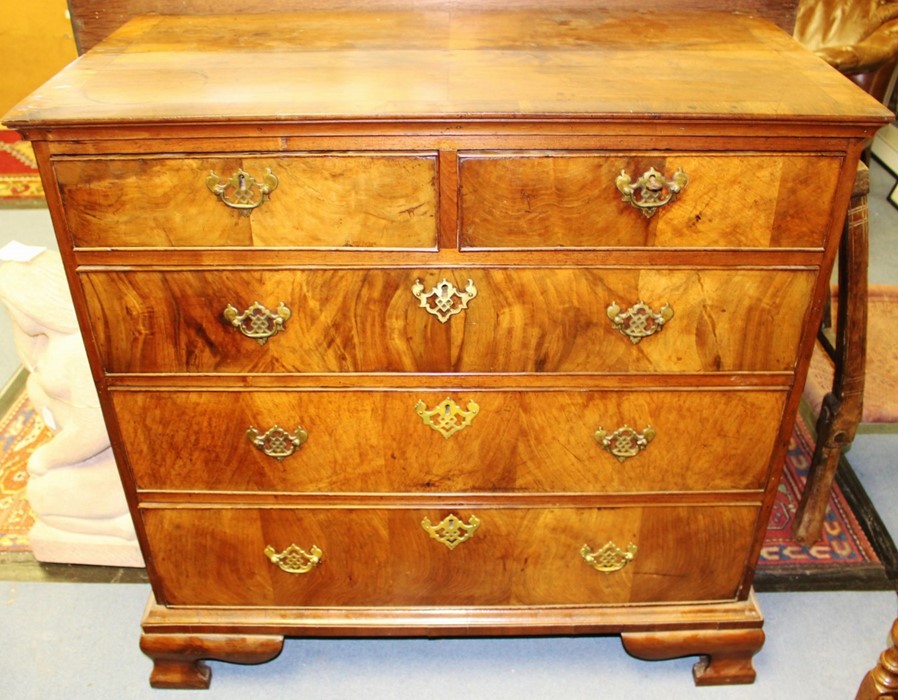 A George I walnut chest of drawers, circa 1720, projected moulded top, fitted with two short over