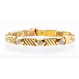 A diamond and 18ct yellow gold set bracelet, comprising alternate chevron textures links and oval