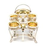 A George III four piece egg cruet, the shaped square frame with gadroon border, incurved sides on