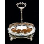 A Victorian silver cruet stand, shaped oval bombe side with mahogany base, the body chased with