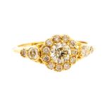 A diamond and 18ct yellow gold cluster ring, comprising a central brilliant cut diamond with a