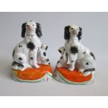 A Pair of Staffordshire Black and White Spaniels and begging Pups, Seated on orange tasselled