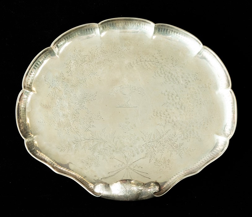 A Victorian silver shell shaped serving dish, the rocaille body with scroll handle on four ball