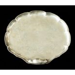 A Victorian silver shell shaped serving dish, the rocaille body with scroll handle on four ball