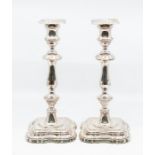 A pair of Elizabeth II silver candlesticks, shaped baluster stems above shaped raised square feet,
