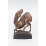 A Chinese carved softwood figure of a horse, possibly Ming Dynasty, modelled in a dramatic pose with