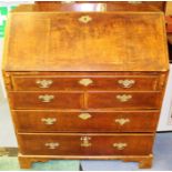 A George I and later walnut bureau, circa 1720, the fall front enclosing drawers, a central door,