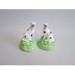 A Pair of Samuel Alcock Wolf Dogs seated on high green rocky bases, each with a ferocious