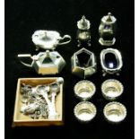 A collection of silver condiment set to include: A George V hexagonal three piece set, by Cooper