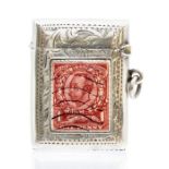 A George V silver vesta case, foliate engraved case with enamel one penny red enamel stamp to the