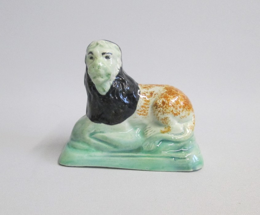 A Staffordshire Model of a recumbent Lion on a green base Date: circa 1800 Size: 9cm diameter, 8cm