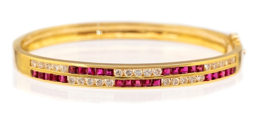 An 18k yellow gold diamond and ruby hinged bracelet, the front with two rows, each channel set