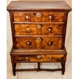 A Queen Anne walnut and elm chest on stand, circa 1705, rectangular top above a moulded cornice,