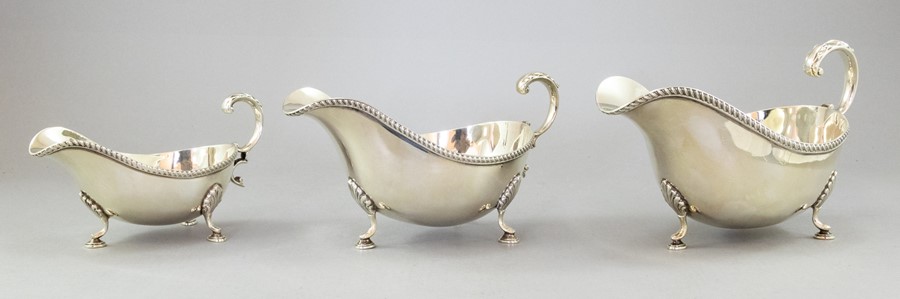 A set of three silver graduated sauce boats, gadroon borders, hoof feet, maker Barker Ellis & Co,