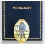 A Moorcroft enamel miniature oval lidded trinket box, decorated with swallows, length 5.5cm, in a