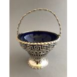 An Edwardian pierced silver sugar basket with Greek key frieze and swing handle, London 1901, ogee