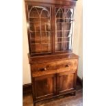 A late George III mahogany bookcase secretaire, circa 1820, moulded pediment above two panel