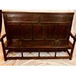 A George III oak five panelled back settle, circa 1760, dental carved cornice on two long moulded