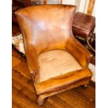 A circa 1920's studded tan leather club armchair, Height 78cm, Width 67cm, Depth 72cm. Condition: