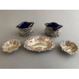 A pair of Edwardian silver pierced oval salts, with scroll embossing, Chester 1901, blue glass