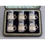 A cased set of six late Victorian silver miniature demitasse, pierced cherub scenes, clear glass