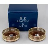 A boxed pair of Mappin & Webb silver wine coasters, pierced sides, turned wooden inserts with