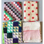 A square patchwork quilt in the form of a throw, in colourways of pink, floral, navy and jade green,