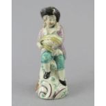 An early nineteenth century pearlware figure, c.1820. It depicts a gleaning man with his sickle