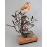 An Albany Fine China Co. ceramic bird study incorporating metal. Modelled as a Robin amongst holly
